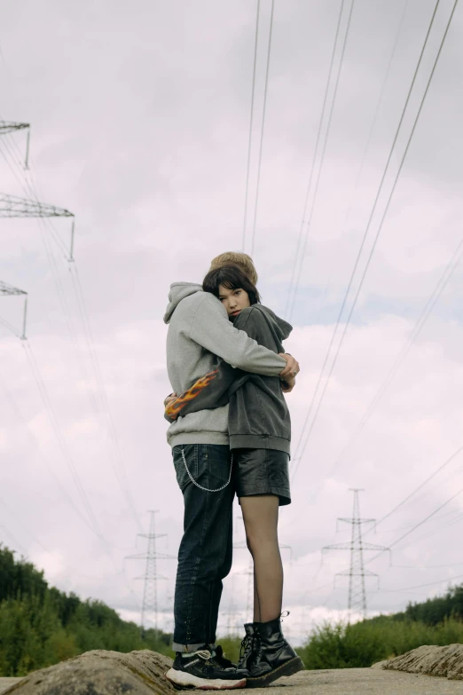 two people kissing on top of a pile of rocks