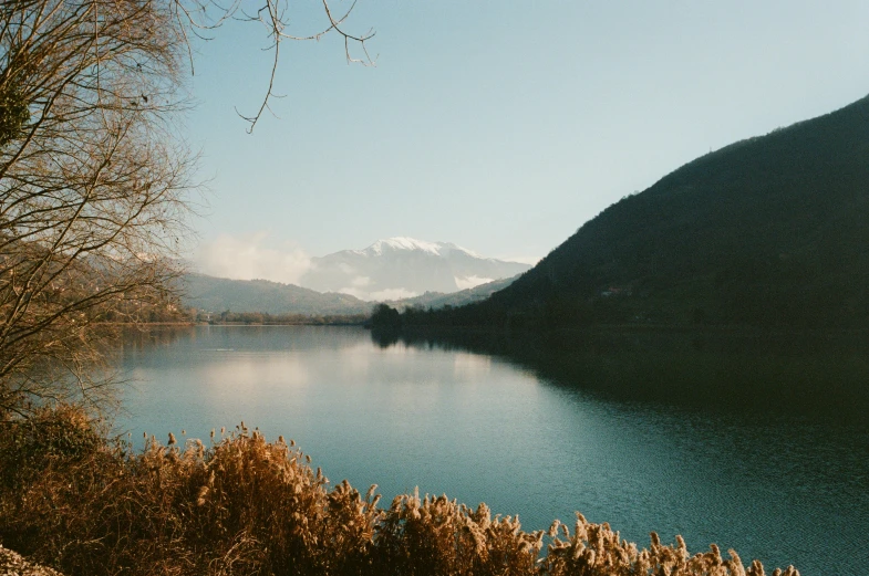 a mountain area with some water and a blue sky