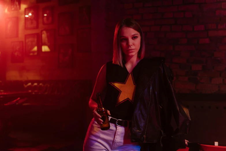 a beautiful blonde girl wearing a star shirt holding a bottle