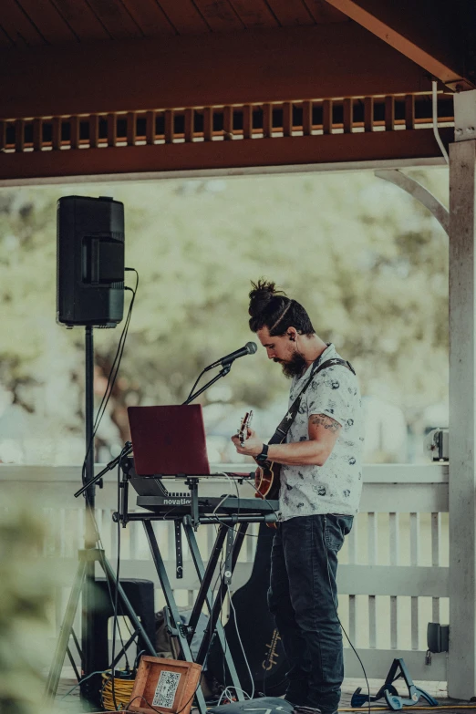 there is a man that is playing the guitar on a stage