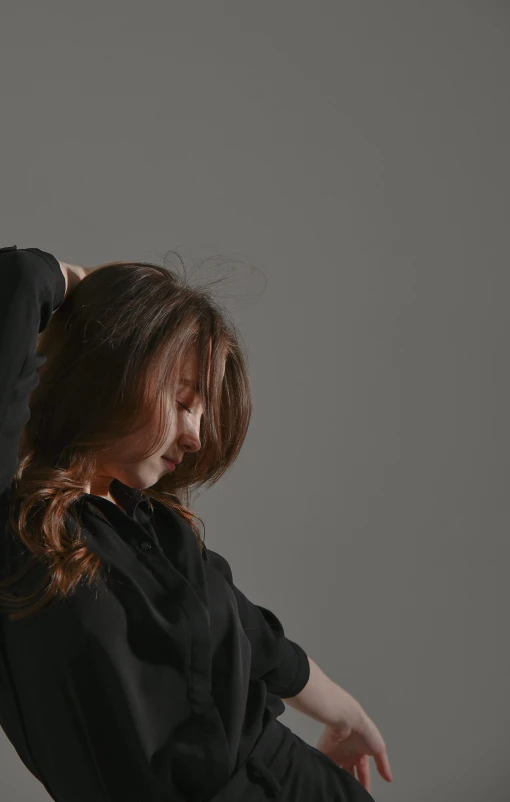 a woman standing and touching her hair