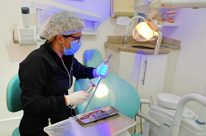 a woman with a dentist mask and eye glasses working on soing in a  room