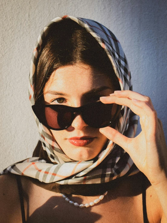 a woman with glasses and a scarf covering her face