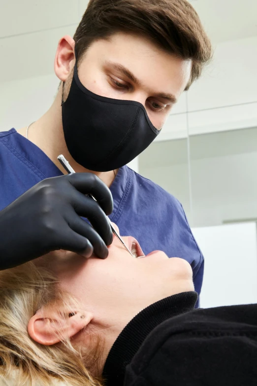 a person getting their eyebrows brushed by a doctor