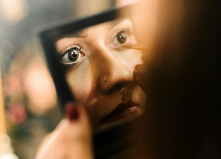 a woman staring into the mirror as she looks at her reflection