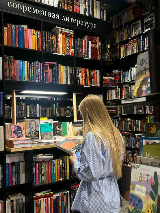 a lady browses the shelves at a book store