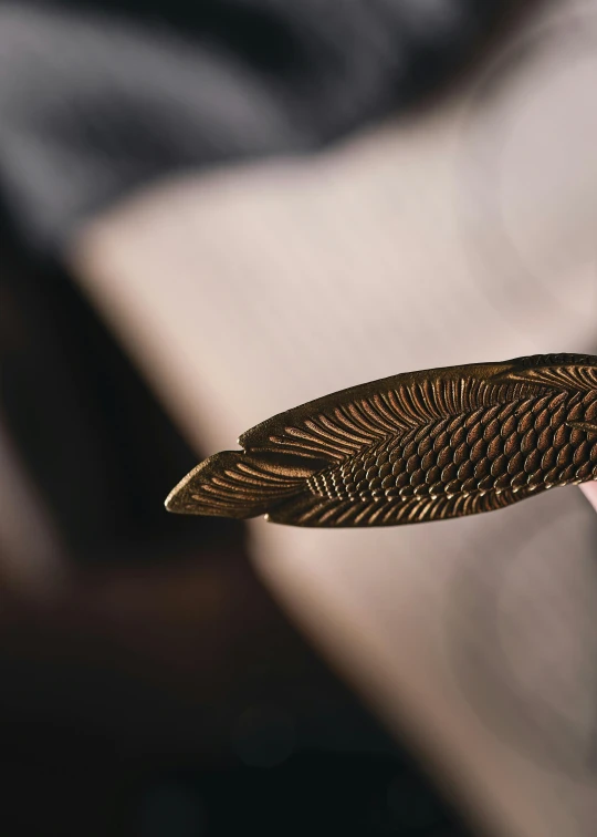 a gold bird wing is on a person's hand