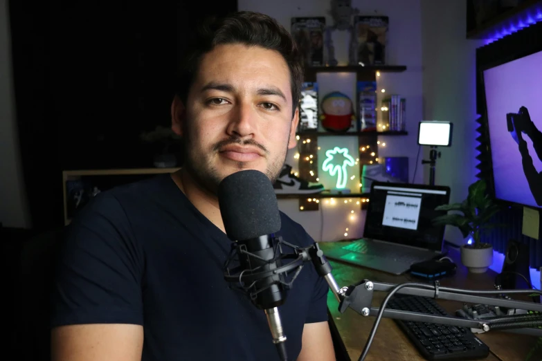 a man is sitting at a desk with a microphone