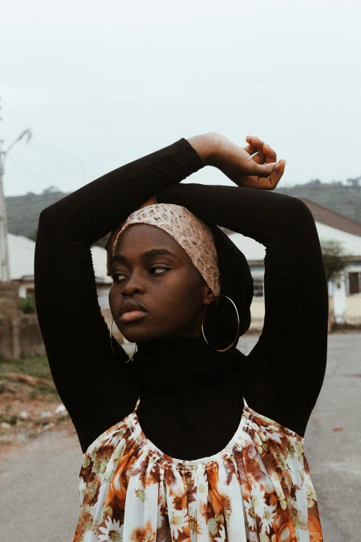 a woman standing with her hands on top of her hair