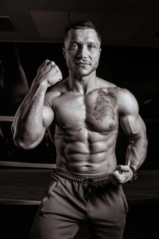 black and white pograph of man flexing his muscles