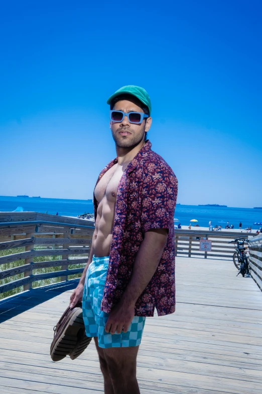 a man wearing sunglasses and a colorful outfit at the beach