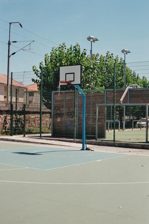 a boy on a basketball court with a basketball hoop