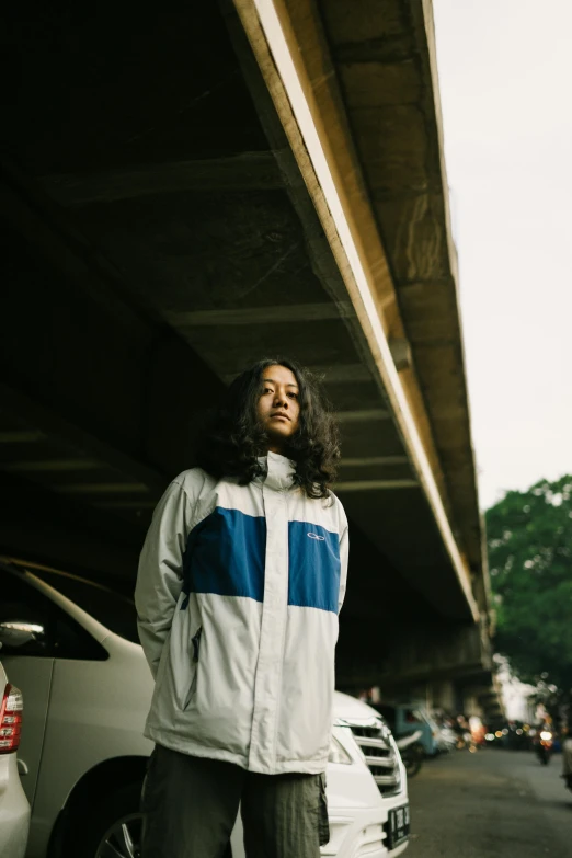 a man standing next to a car and a bridge