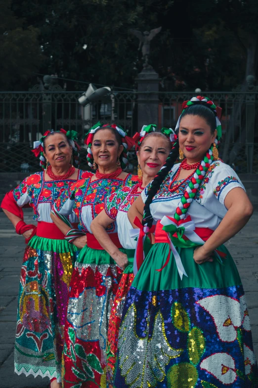 a group of women in colorful outfits posing for a picture