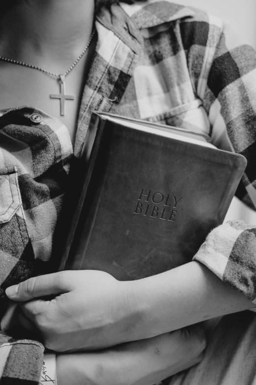 a close up of a person holding a bible