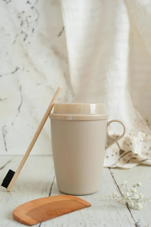 a cup and a brush sit on a table