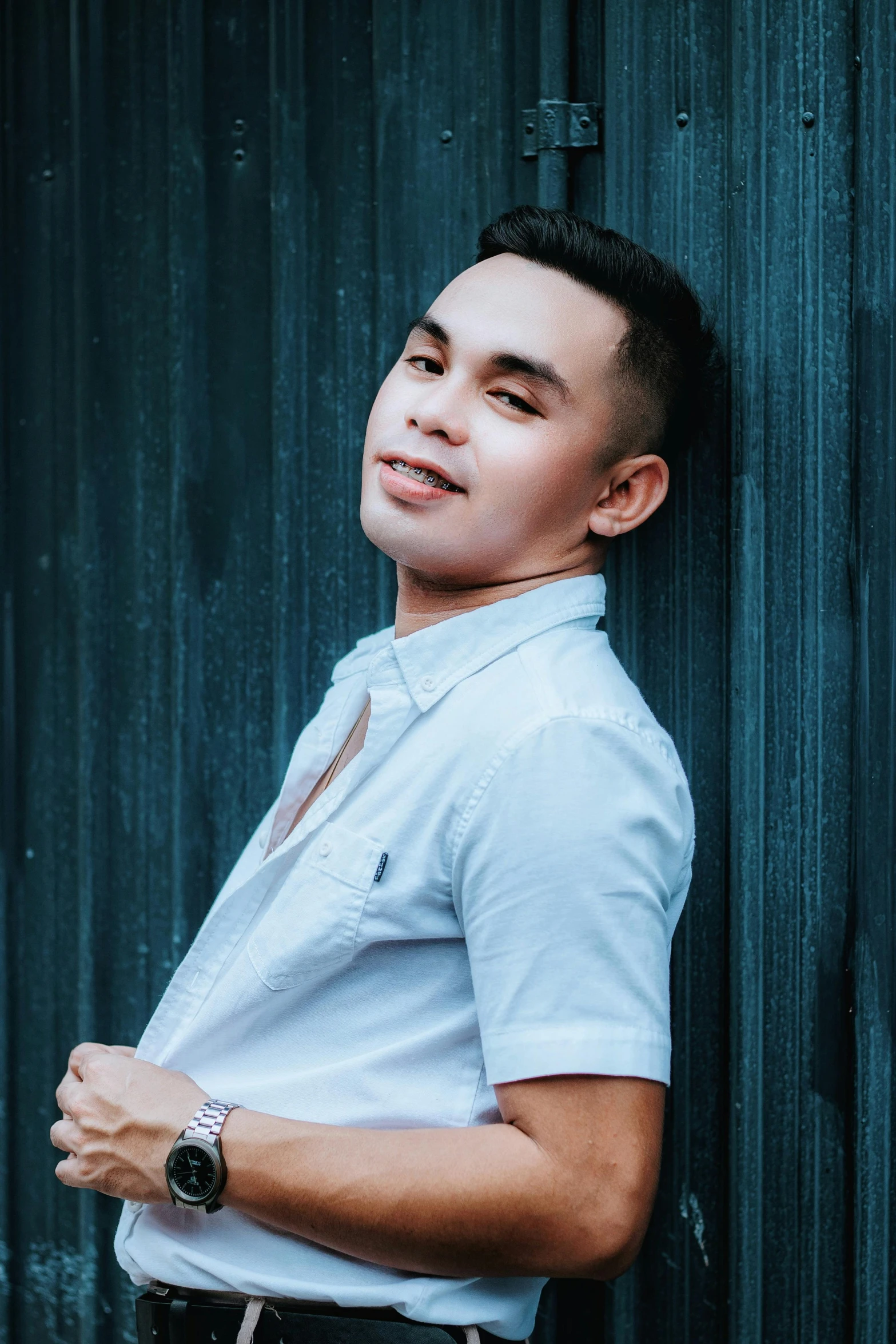 man leaning against wall looking at soing with serious expression