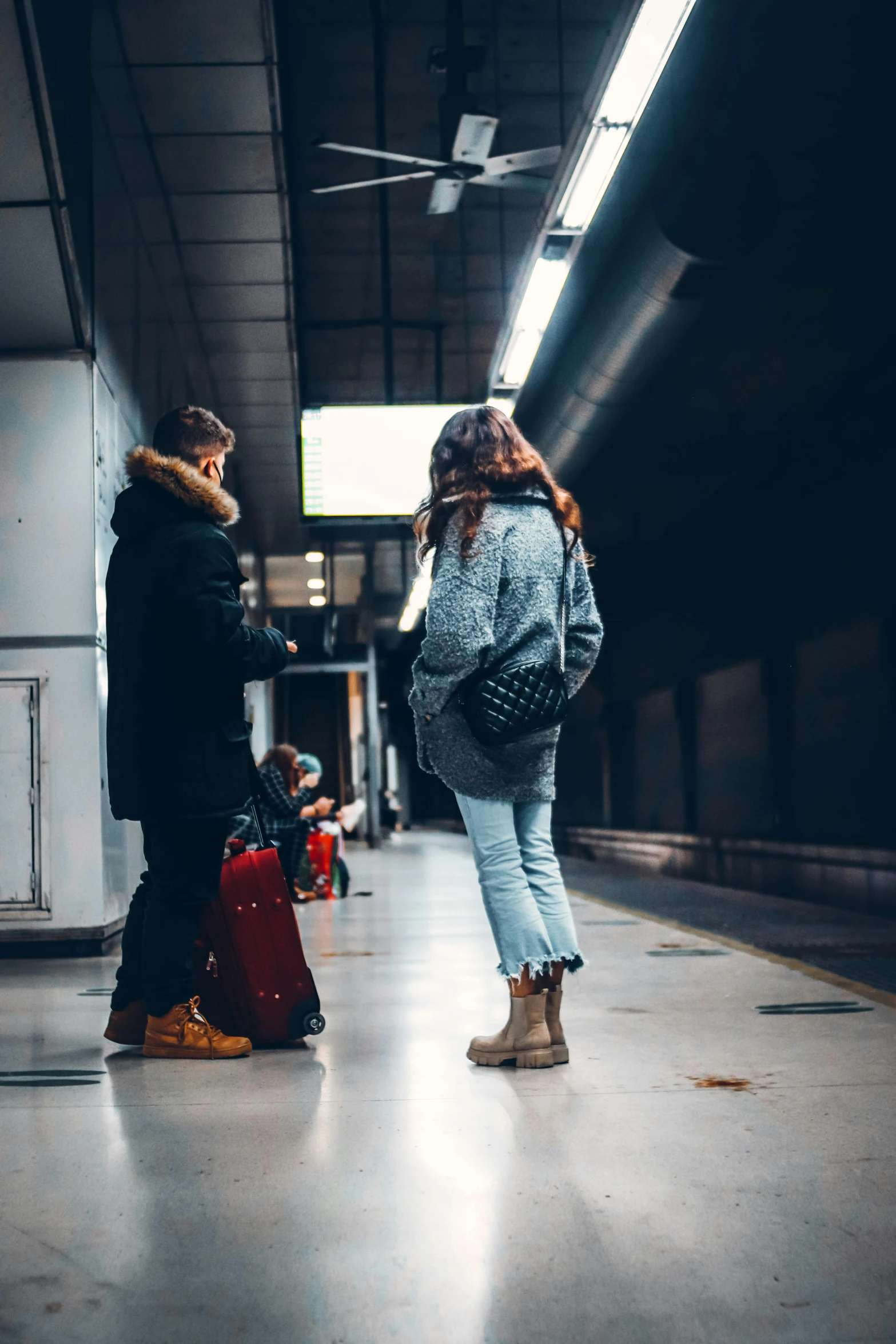 a woman standing next to another woman with luggage