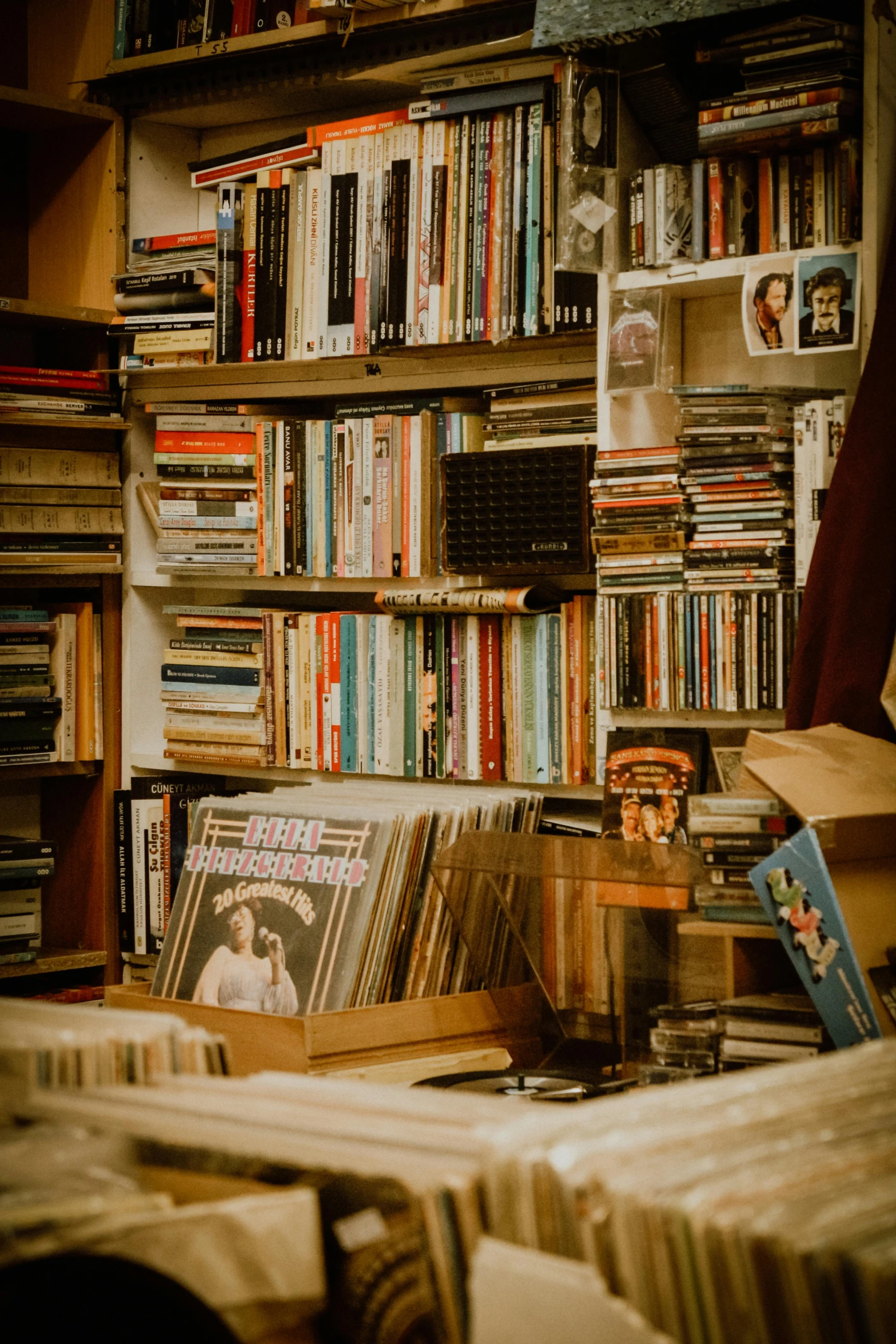 a room filled with stacks of books and cassettes