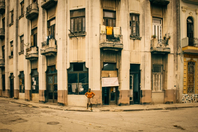 an empty street in front of a building with balconies