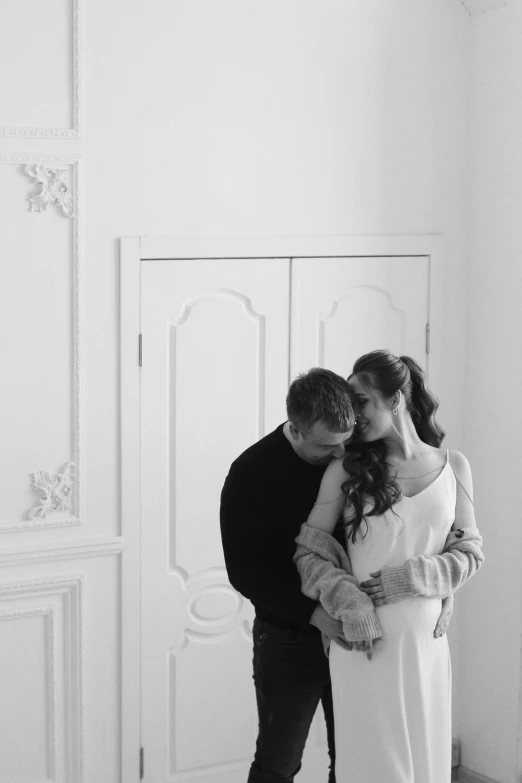 a man and woman standing next to each other in a room