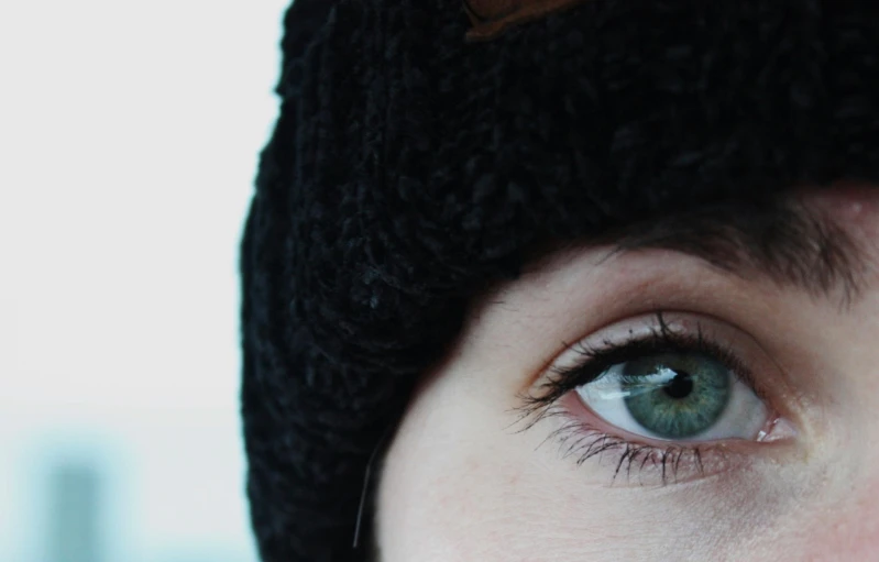 a woman's eyes are showing with brown and black hats