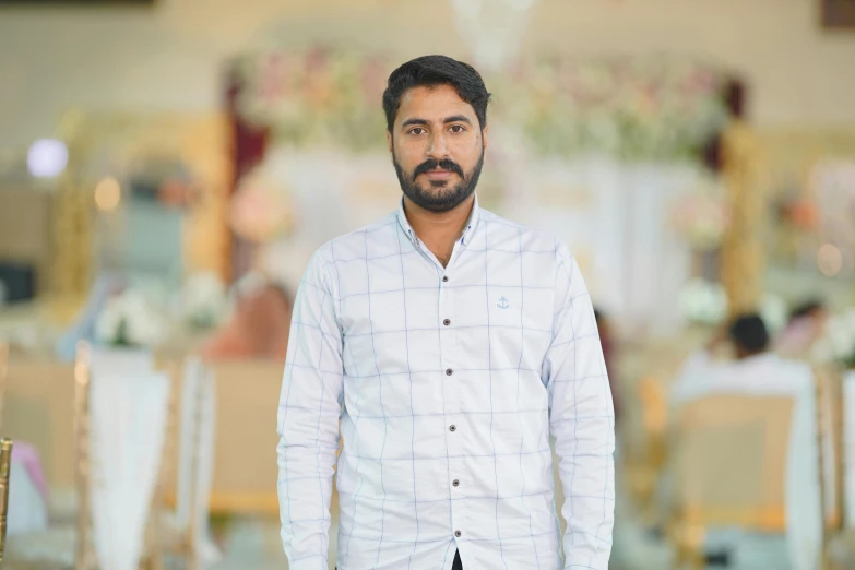 a man standing in a dress shirt with his hands in pockets