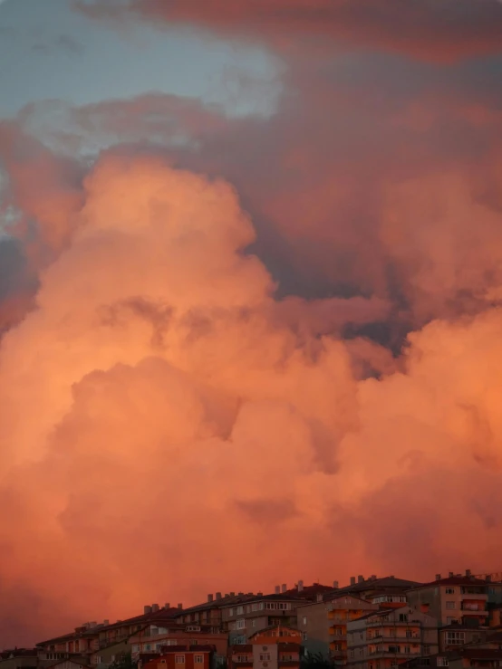 a very colorful cloud above some town and trees