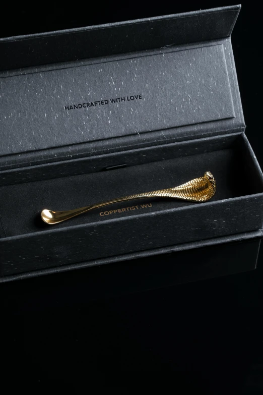 gold scissors are in an opened gift box