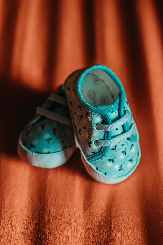 a pair of baby blue sneakers on top of a blanket