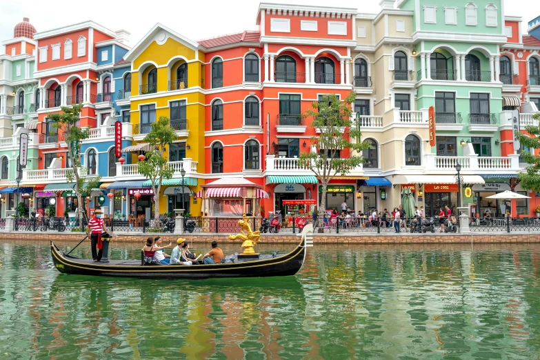 a boat in a harbor in front of a row of colorful buildings