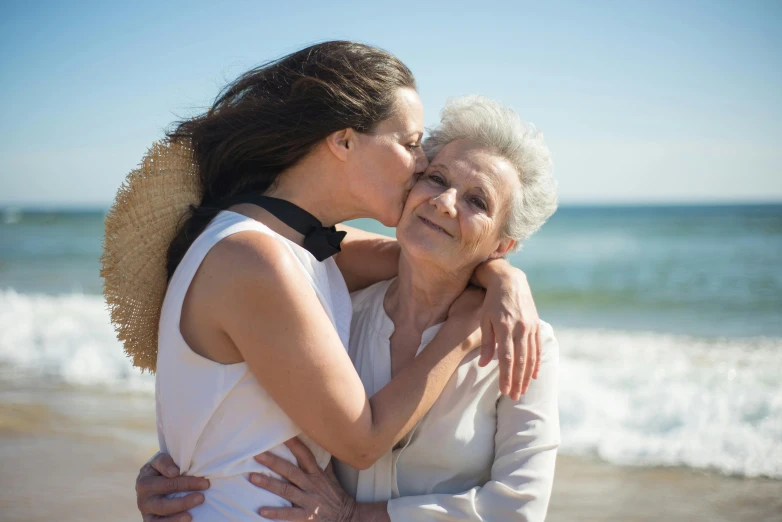 the older woman is kissing the younger lady