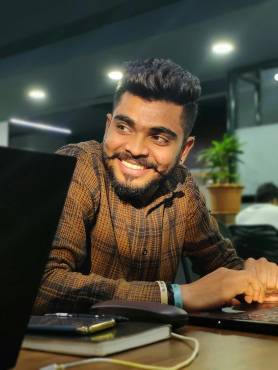 a man sitting with his laptop on the table in front of him