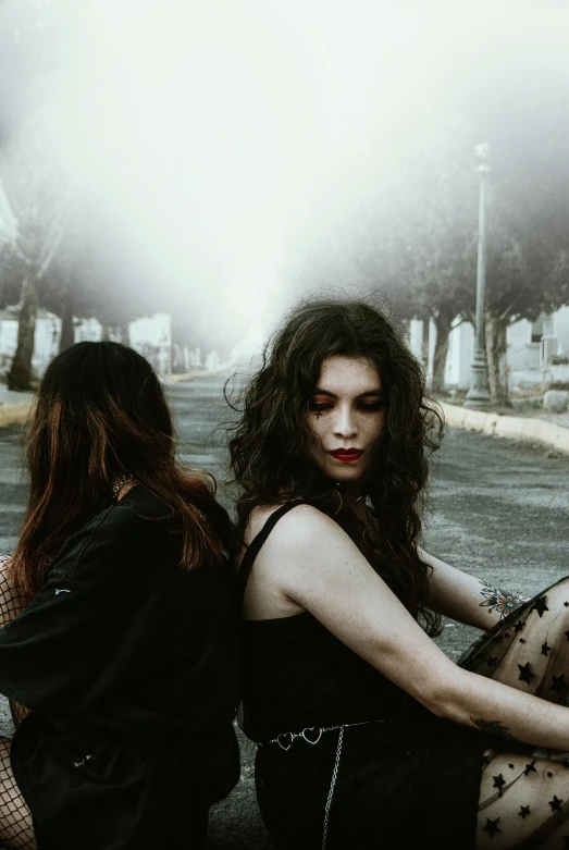 two beautiful women riding on the back of a motorcycle