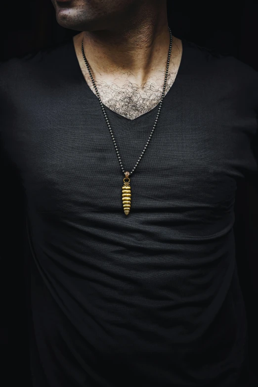 man wearing a small, gold - tone necklace