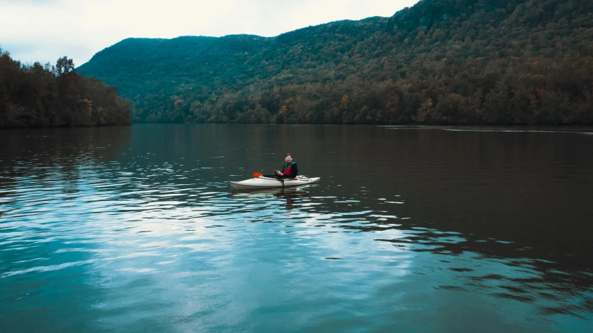 a man riding in a boat across a lake