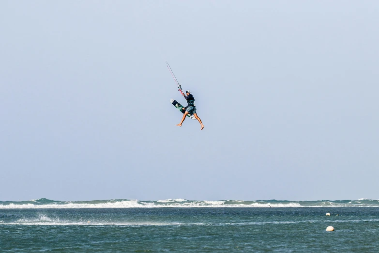 man jumping with skis while attached to a wakeboard