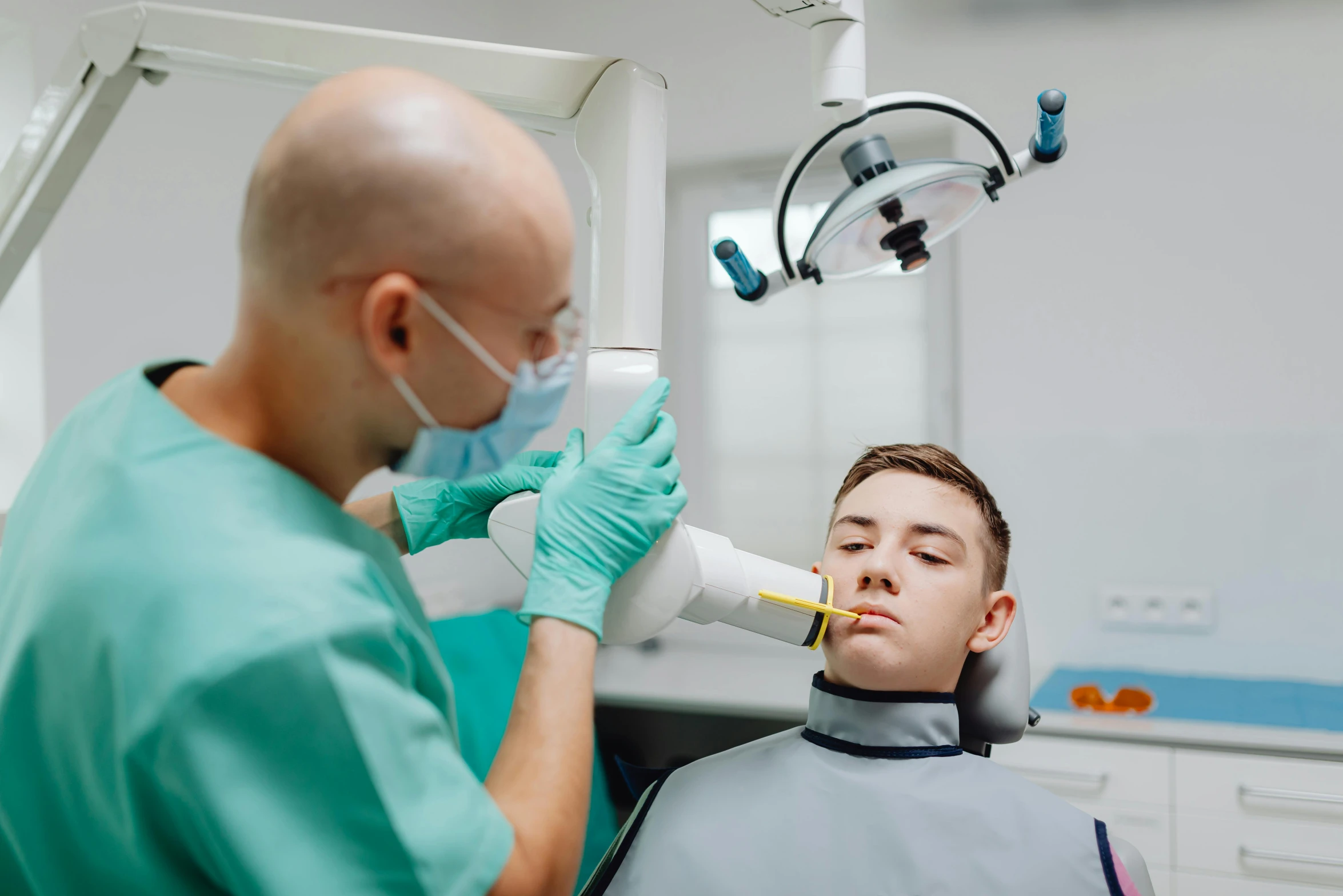 a man with green uniform and gloves getting dental practice