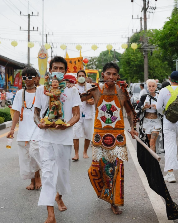 many people are carrying small objects and walking down the street