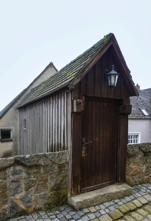 an old building with a wooden door and brick pavers around it