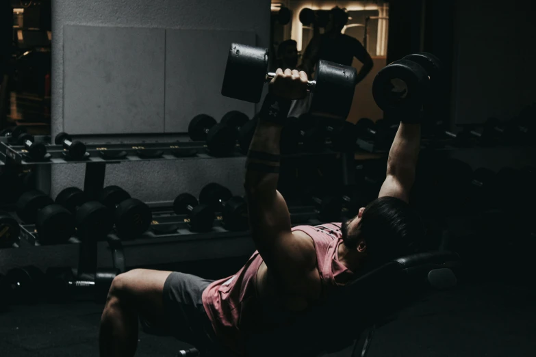 woman laying on chair working her arms with dumbs