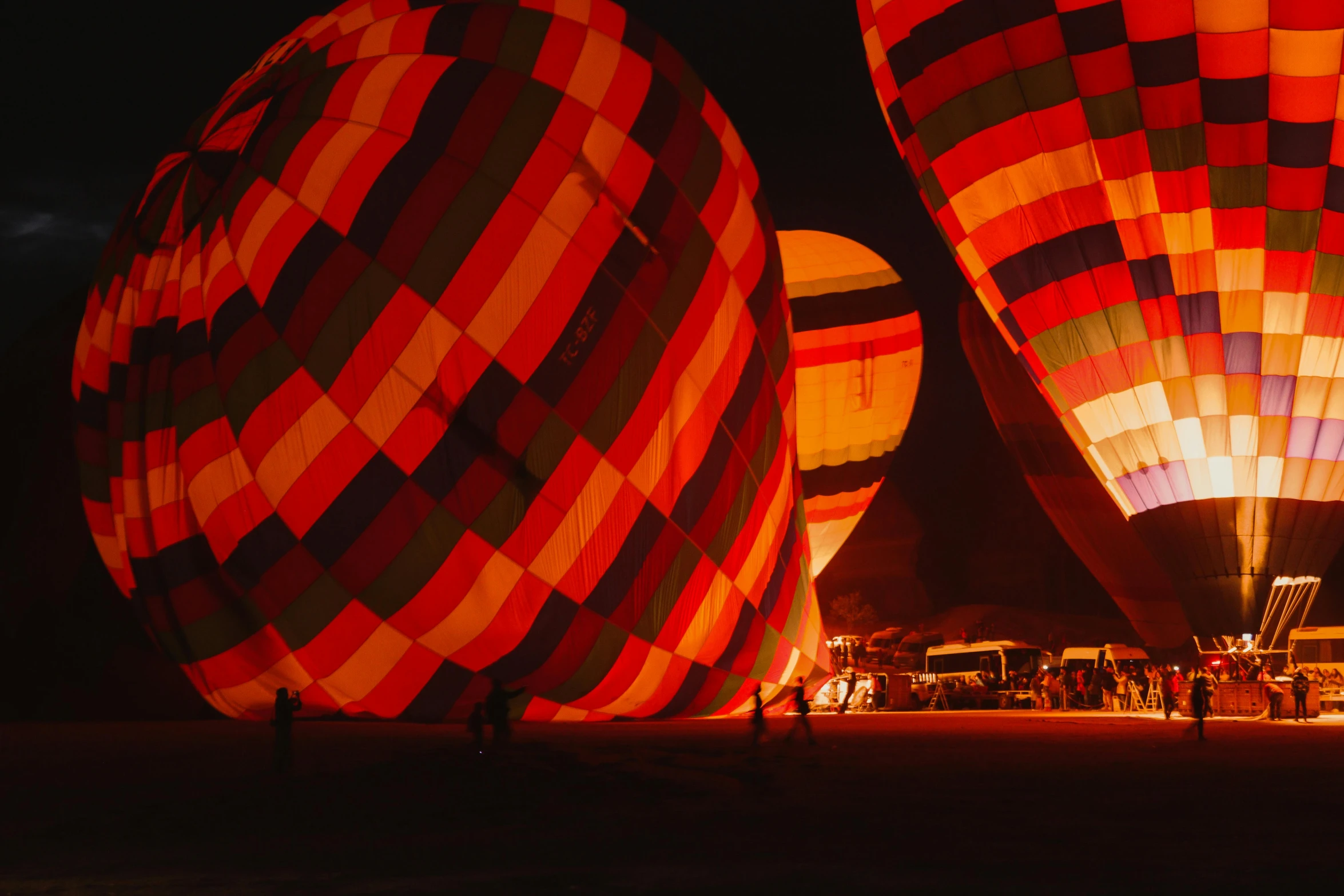 three large  air balloons are lit up at night