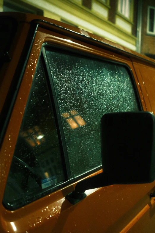 the rear end window of an orange pick - up truck