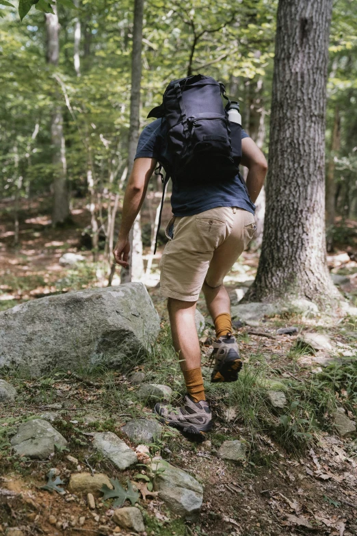 a man hiking up a dirt trail in the woods