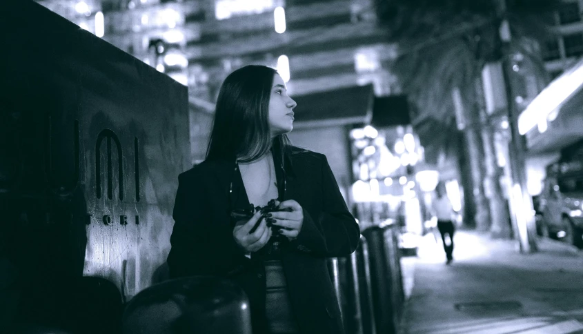 a woman standing on the side walk near the sidewalk