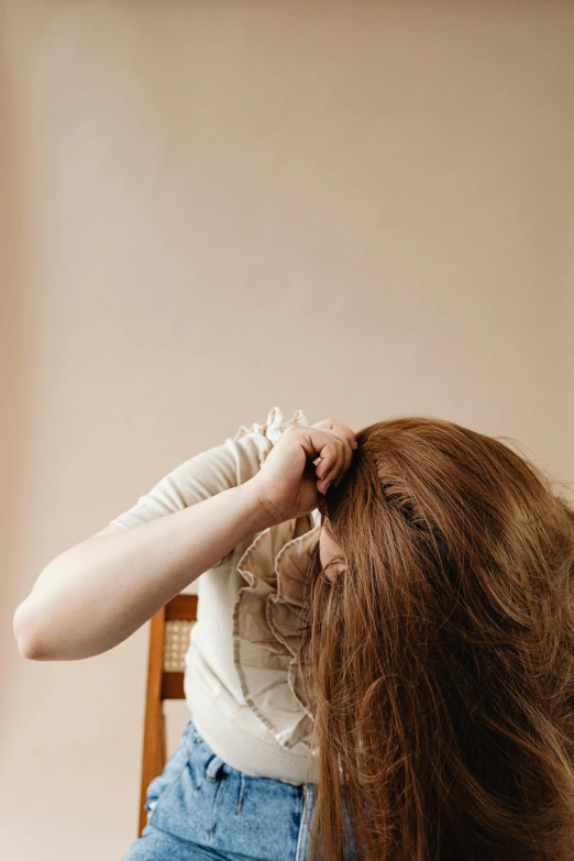 a girl holding her hair up in front of her head