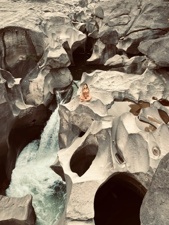 a woman sits in the middle of a pool of water