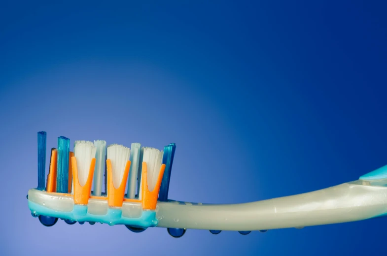 a blue toothbrush with four toothpastes is shown