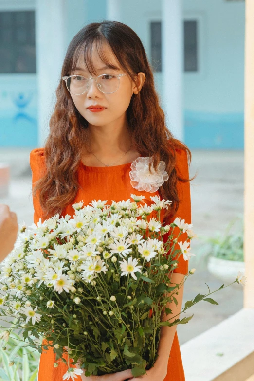 a woman is holding a large bouquet of white flowers