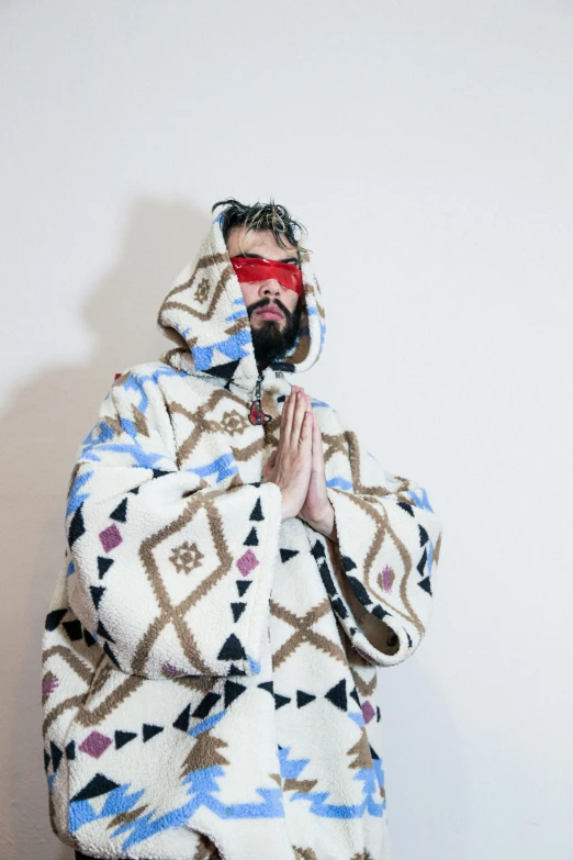 a man with glasses on his face, covered in a blanket